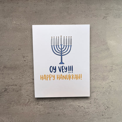 Impish Greetings Hanukkah card featuring a blue menorah illustration with the text Oy Vey and Happy Hanukkah