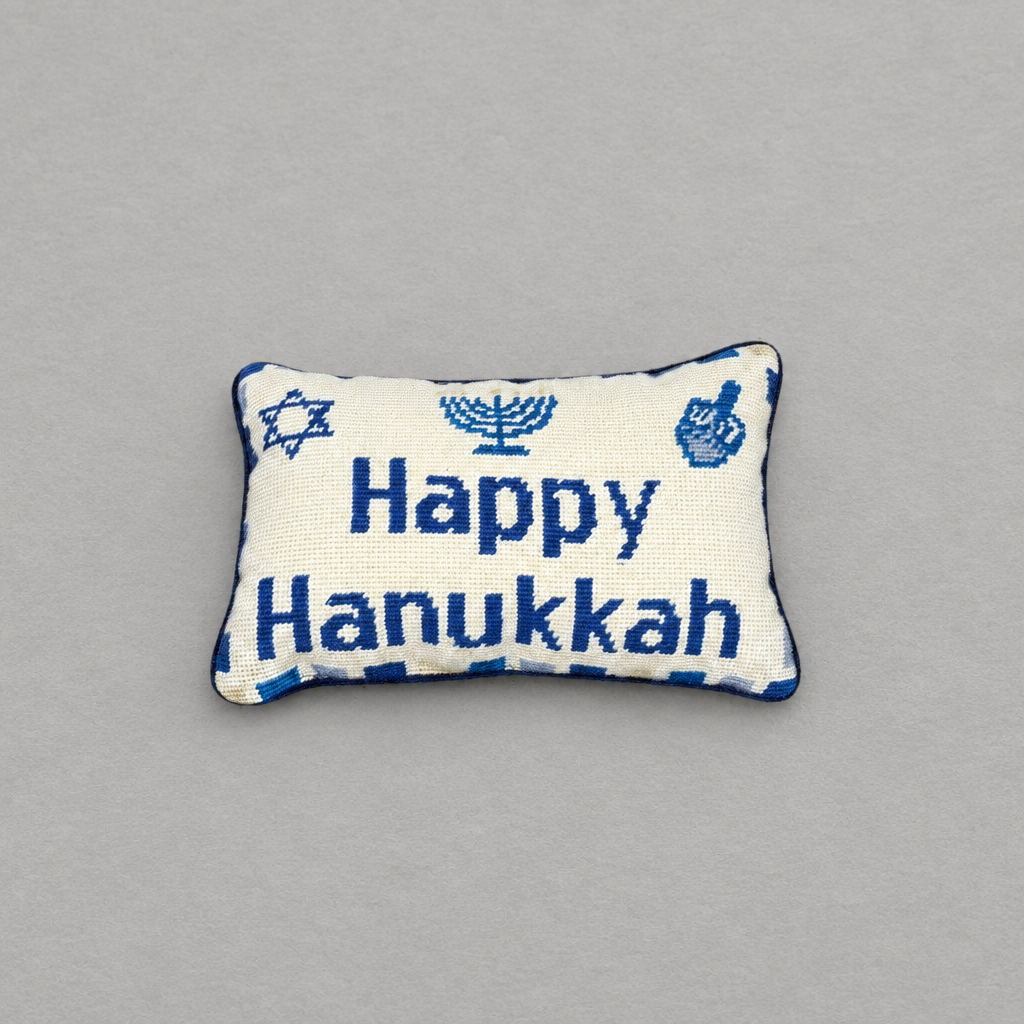 Impish Greetings Happy Hanukkah needlepoint pillow with blue menorah, dreidel, and Star of David on cream wool.
