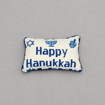 Impish Greetings Happy Hanukkah needlepoint pillow with blue menorah, dreidel, and Star of David on cream wool.