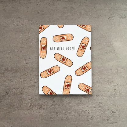Impish Greetings Heart Bandaid get well soon greeting card with a pattern of adhesive bandages on white cardstock