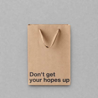 Impish Greetings kraft paper gift bag with the text Don't get your hopes up printed in black on the front.