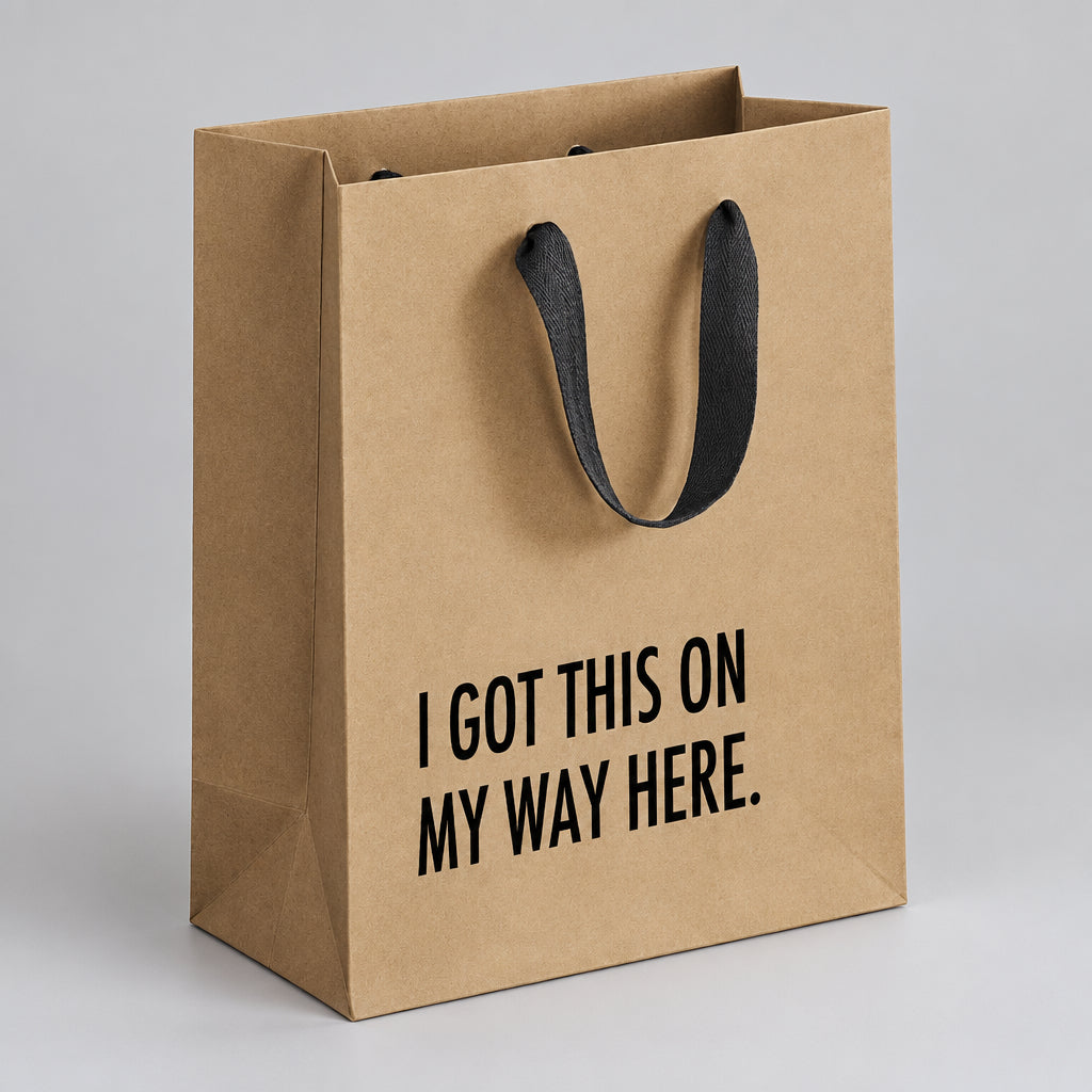 Impish Greetings kraft paper gift bag with black cloth handles and I Got This on my Way Here text in black print.