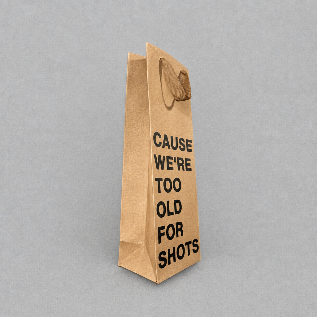 Impish Greetings kraft paper wine gift bag with black text reading Cause We're Too Old For Shots