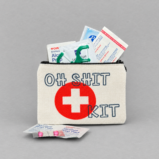 Impish Greetings linen mini zipper bag with Oh Shit Kit text and red medical cross, filled with emergency supplies.