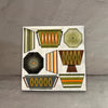 Impish Greetings mid-century modern cocktail napkin with retro Pyrex-inspired geometric patterns in earthy tones.