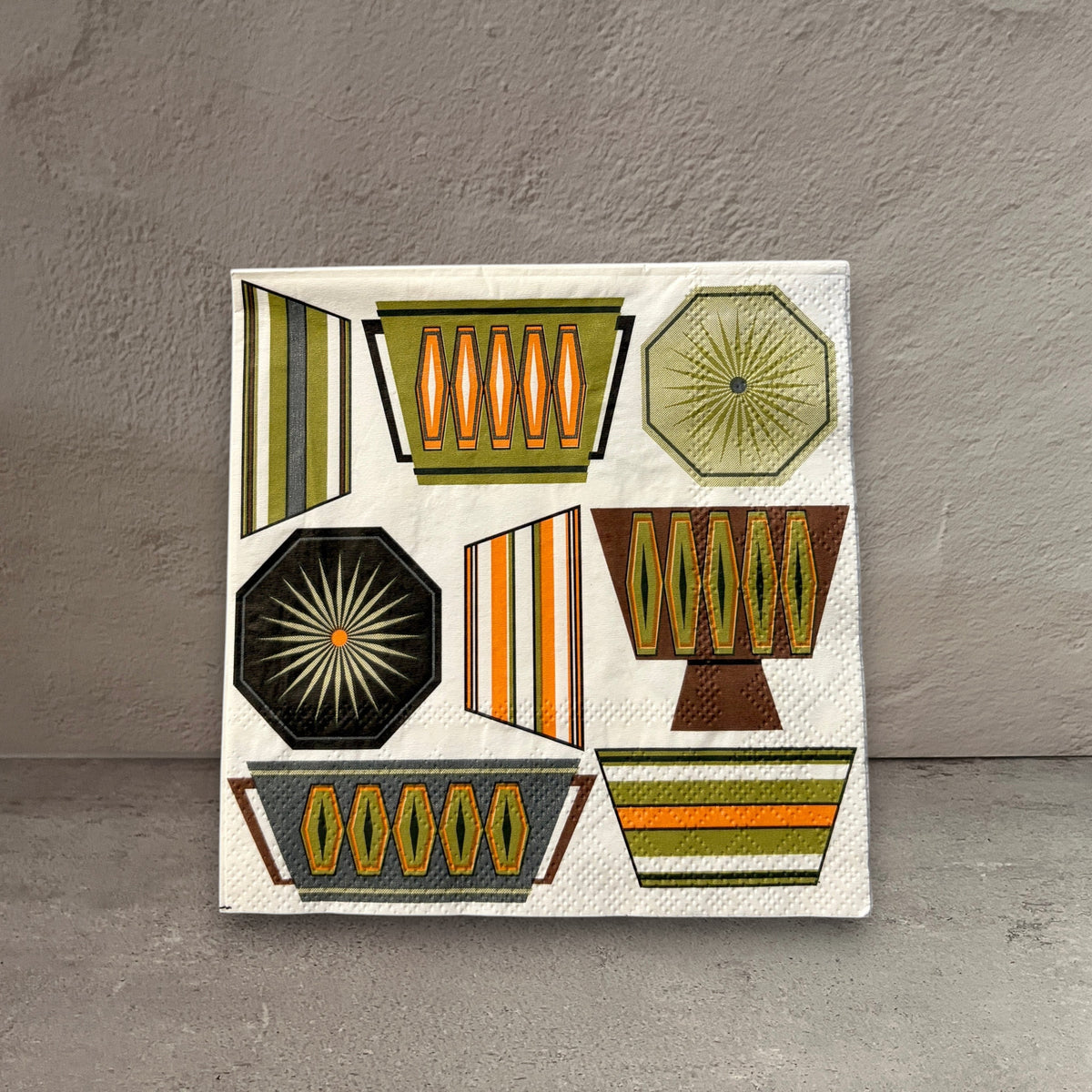 Impish Greetings mid-century modern cocktail napkin with retro Pyrex-inspired geometric patterns in earthy tones.