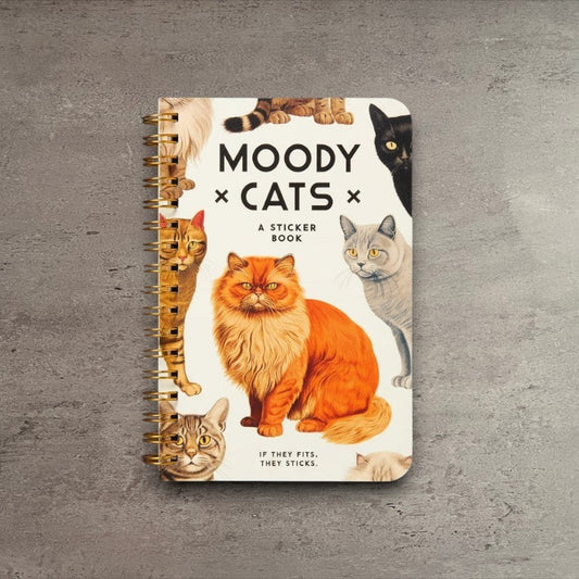 Impish Greetings Moody Cats sticker book with vintage cat illustrations and gold spiral binding on a grey surface.