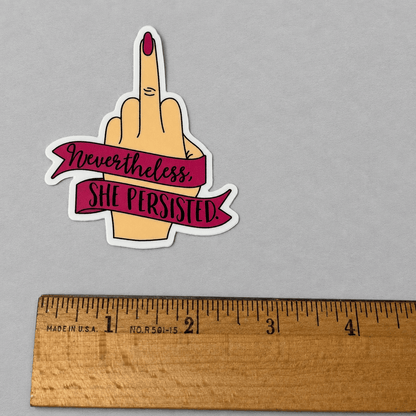 Impish Greetings vinyl sticker featuring a hand with a middle finger gesture and a banner reading Nevertheless She Persisted