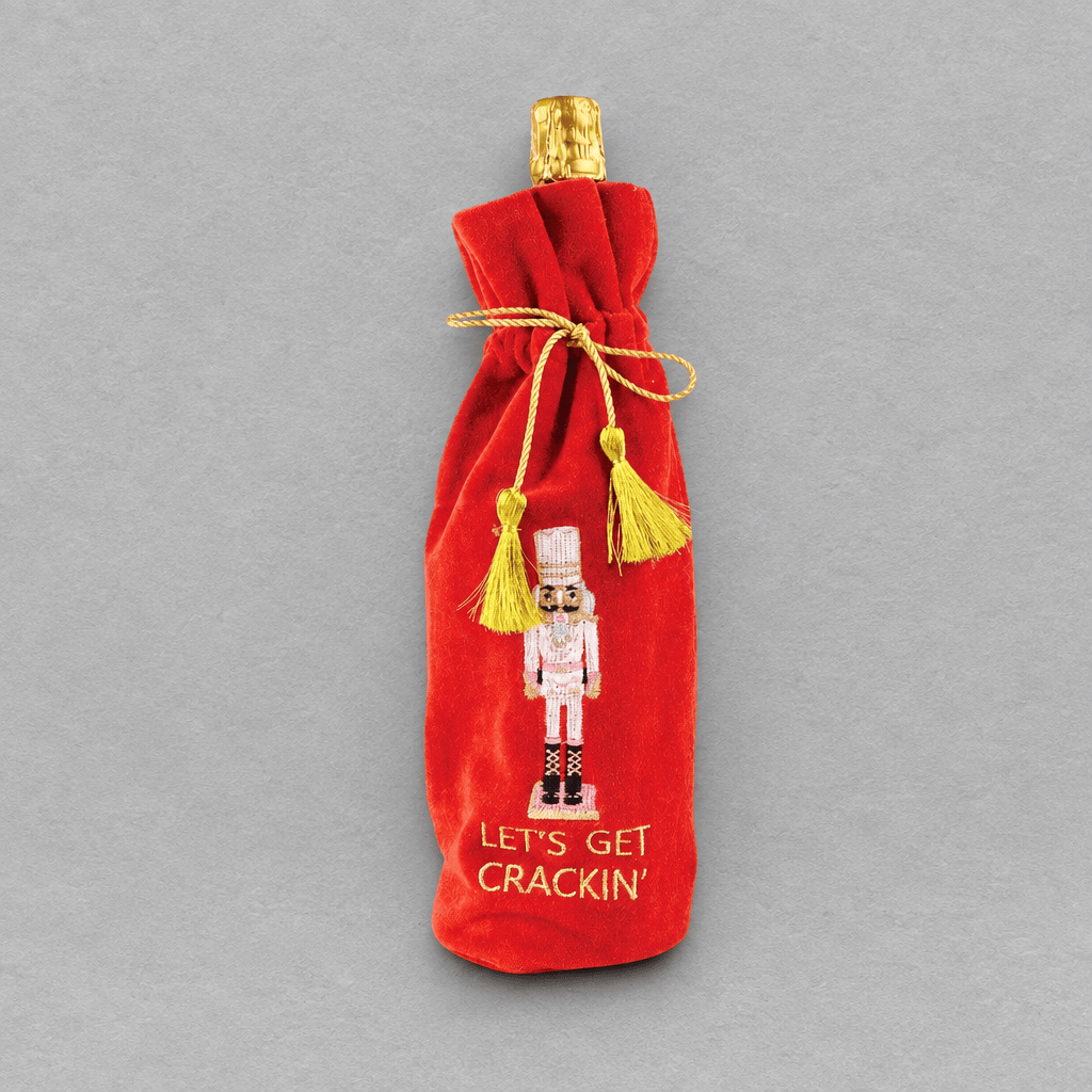 Impish Greetings red velvet wine gift bag featuring nutcracker embroidery and gold tassel closure
