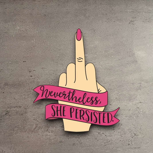 Impish Greetings Nevertheless She Persisted vinyl sticker featuring a hand with a pink nail giving the middle finger