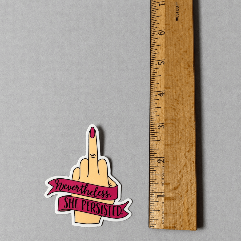 Impish Greetings Nevertheless She Persisted vinyl sticker featuring a hand giving the middle finger on a grey surface
