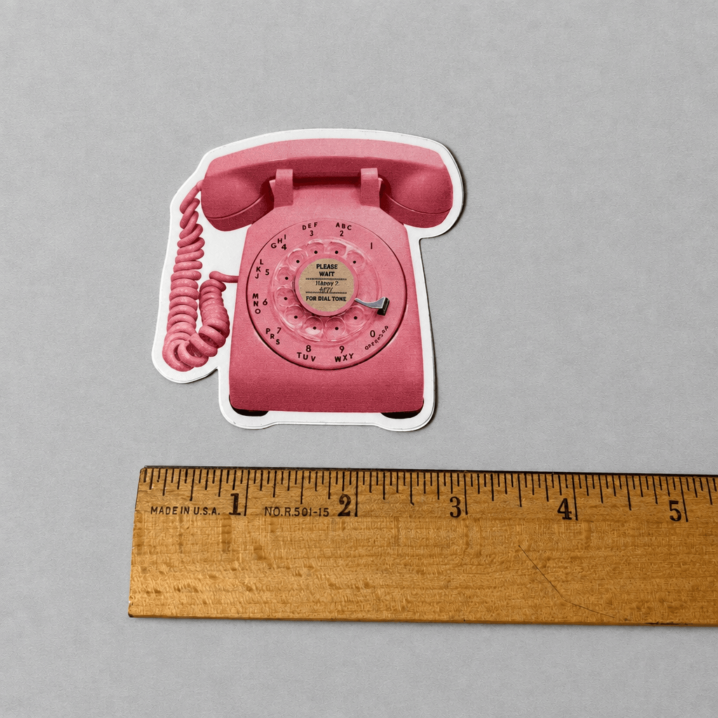 Impish Greetings retro pink rotary phone vinyl sticker with a matte finish, shown next to a wooden ruler for scale.