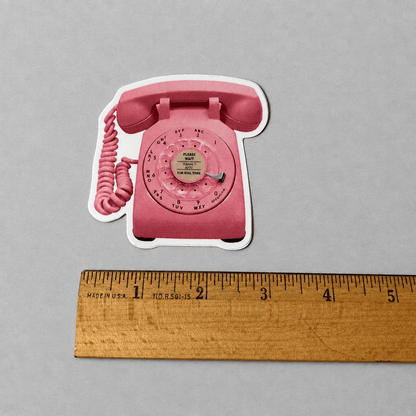 Impish Greetings retro pink rotary phone vinyl sticker with a matte finish, shown next to a wooden ruler for scale.