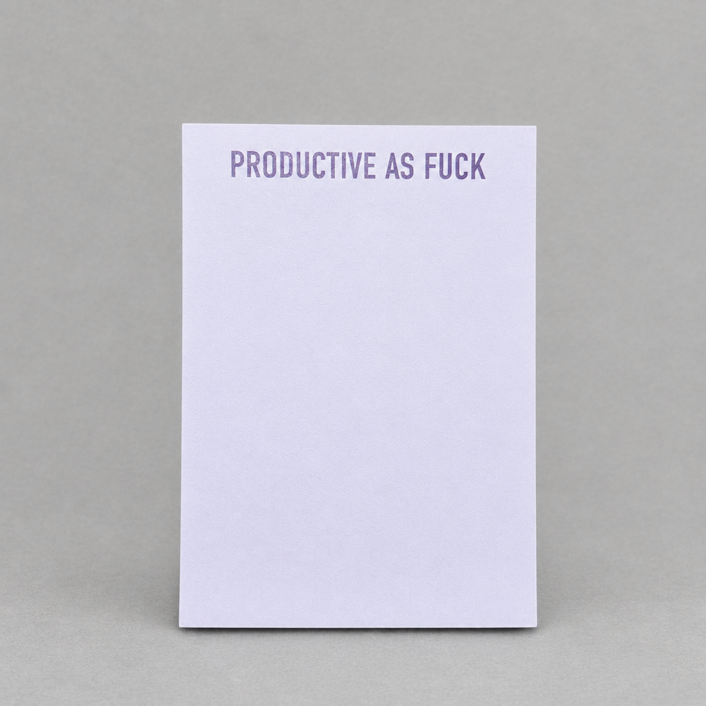 Impish Greetings Productive As Fuck notepad with purple text on a light purple paper background.