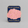 Impish Greetings Professional Over-thinker enamel pin with a pink brain design on a navy background and gold plating.