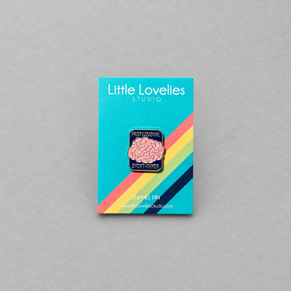 Impish Greetings Professional Over-thinker enamel pin with a pink brain design and gold plating on a display card.