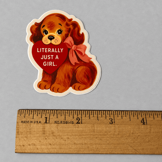 Impish Greetings Literally Just a Girl vinyl puppy sticker with a red heart and bow on a grey background.