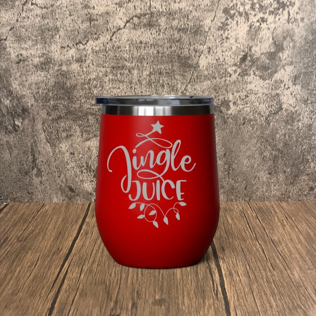 Impish Greetings red metal tumbler with Jingle Juice engraving and clear lid on a wooden surface