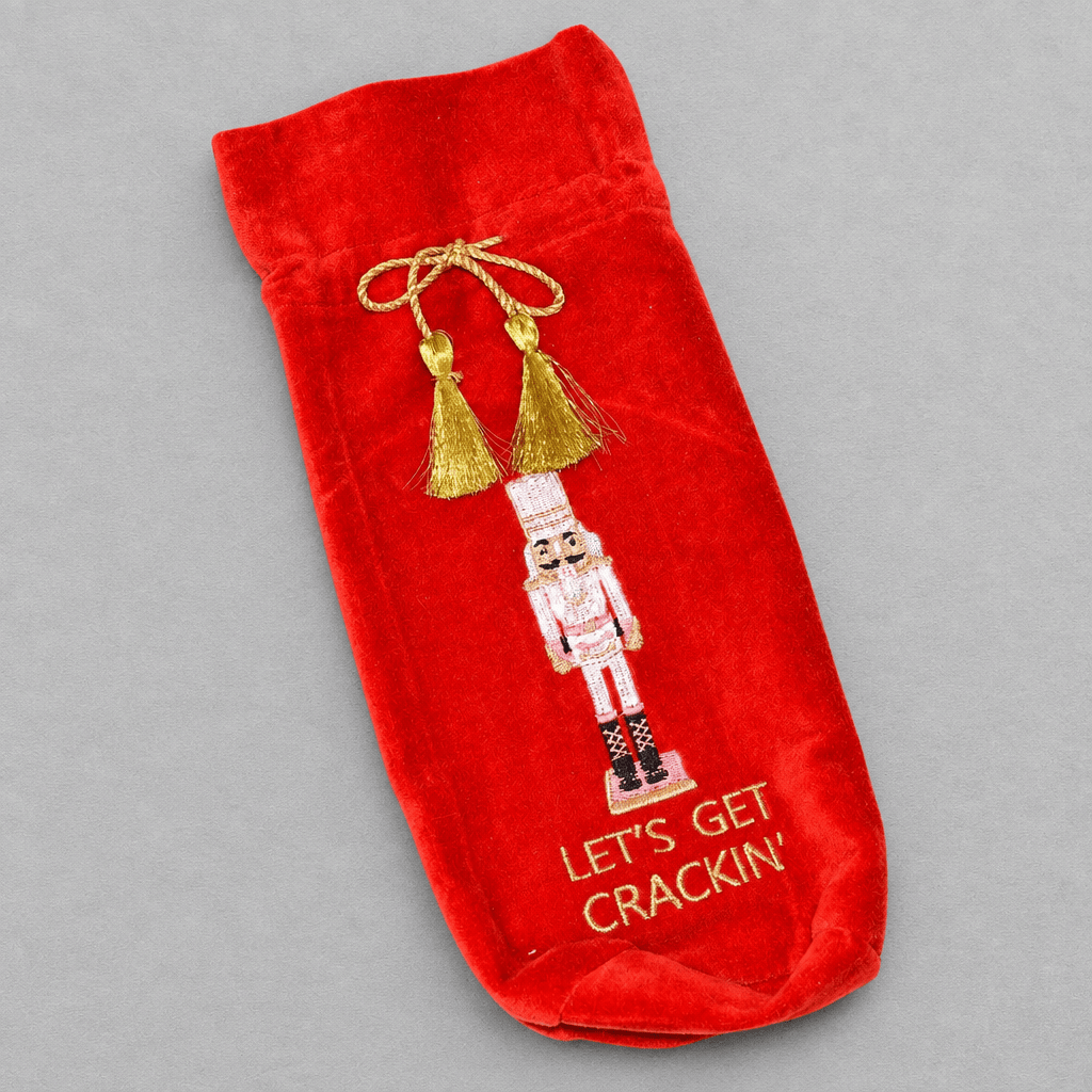 Impish Greetings red velvet wine gift bag featuring nutcracker embroidery and gold tassel drawstring closure