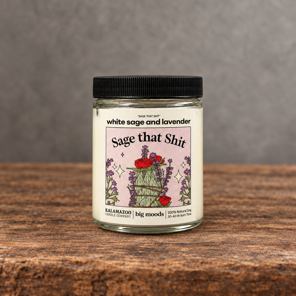 Impish Greetings Sage That Shit soy candle with white sage and lavender scent in a glass jar on a wooden surface