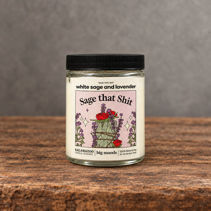 Impish Greetings Sage That Shit soy candle with white sage and lavender scent in a glass jar on a wooden surface
