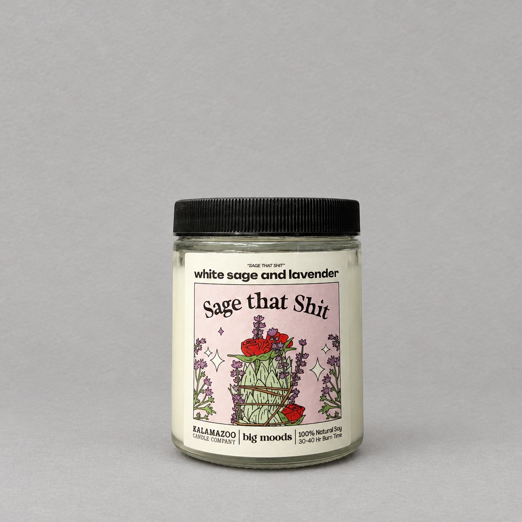 Impish Greetings Sage That Shit soy candle with white sage and lavender scent in a glass jar with a black lid.