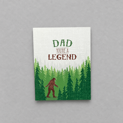 Impish Greetings Sasquatch Legend Dad card featuring a Bigfoot illustration in a forest with text Dad You're a Legend