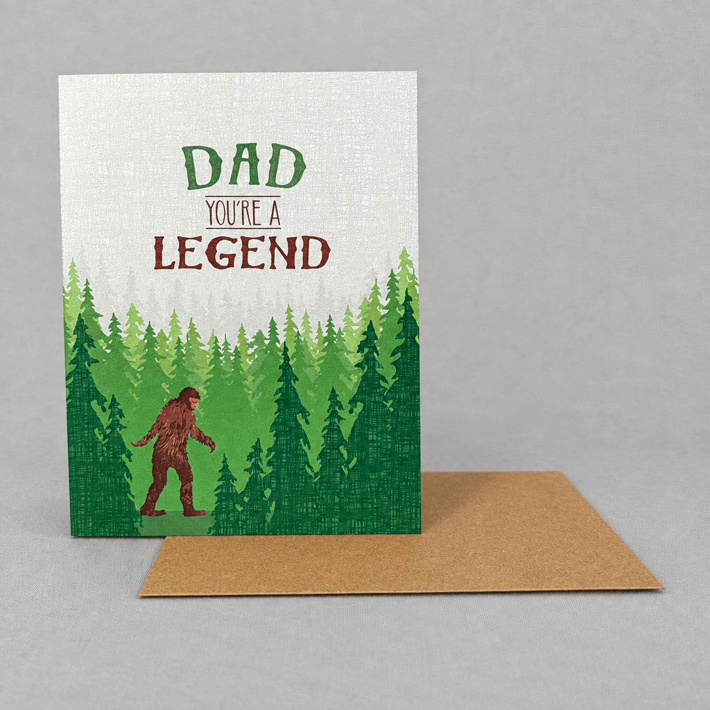 Impish Greetings Sasquatch Legend Dad card featuring a Bigfoot illustration in a forest with a brown kraft envelope.