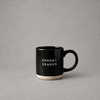 Impish Greetings black stoneware coffee mug with Spooky Season text and a natural speckled base