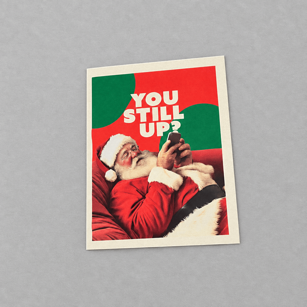 Impish Greetings Still Up? Christmas card featuring Santa Claus looking at his smartphone on a red background.