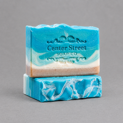 Impish Greetings Summer Cottage artisan soap bars with blue and white coastal swirl patterns on a grey background