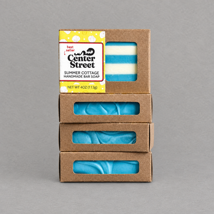 Impish Greetings Summer Cottage handmade bar soap stacked in recyclable kraft boxes with window cutouts.