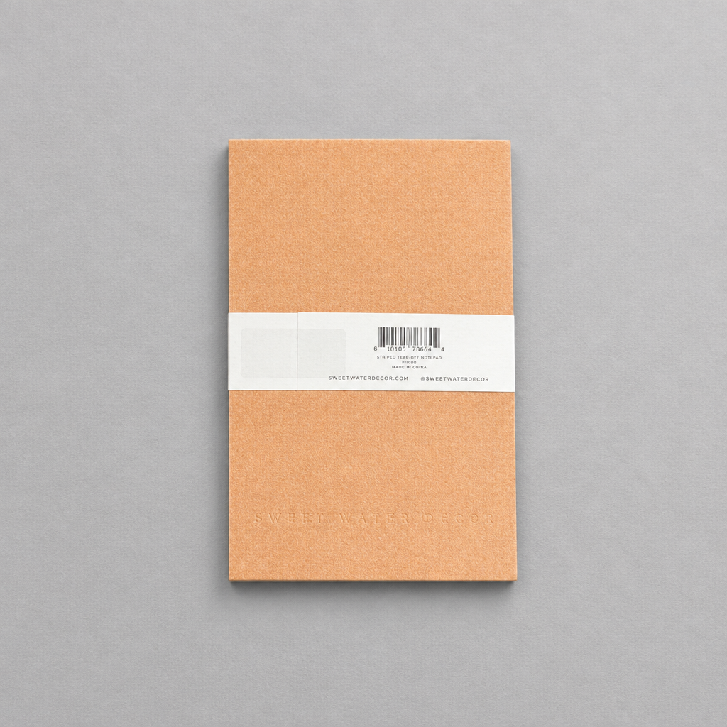 Impish Greetings Striped Notepad with tan cover and white paper band on a grey background