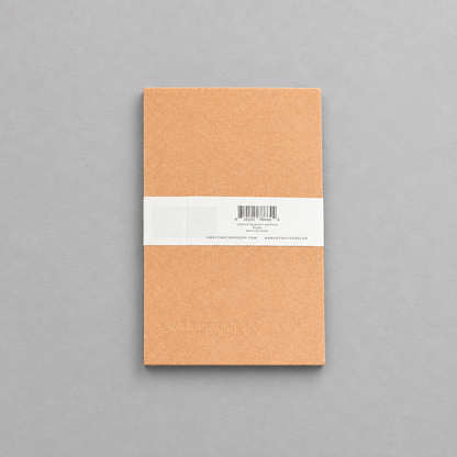 Impish Greetings Striped Notepad with tan cover and white paper band on a grey background