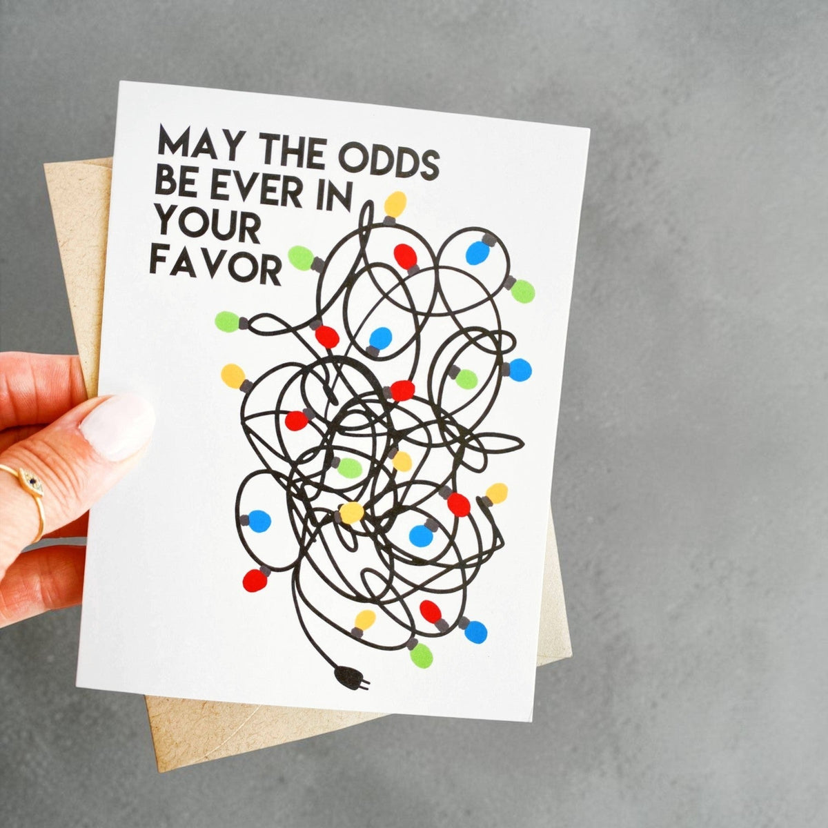 Impish Greetings funny Christmas card featuring a tangled string of colorful holiday lights and humorous text.