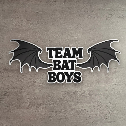 Impish Greetings Team Bat Boys clear vinyl sticker featuring black bat wings on a wood grain background