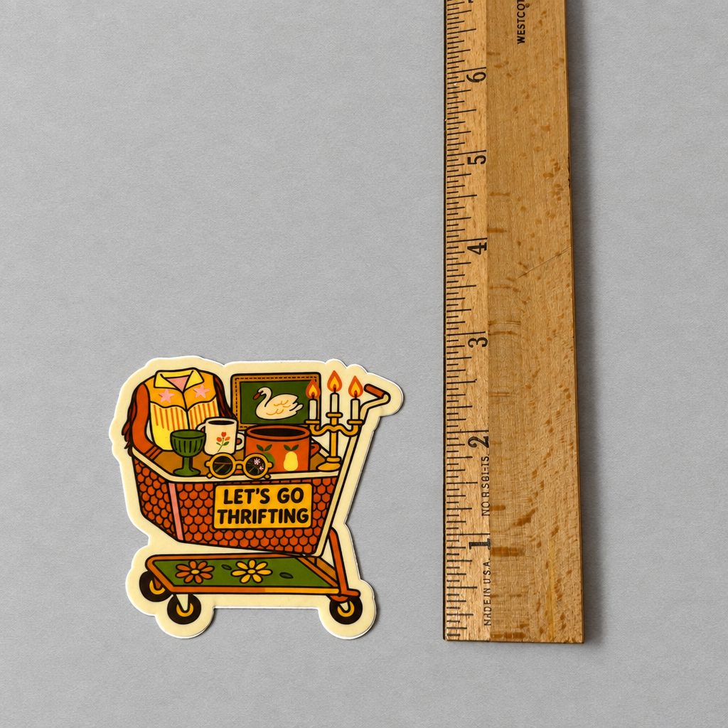 Impish Greetings Let's Go Thrifting sticker featuring a shopping cart filled with vintage treasures next to a ruler.