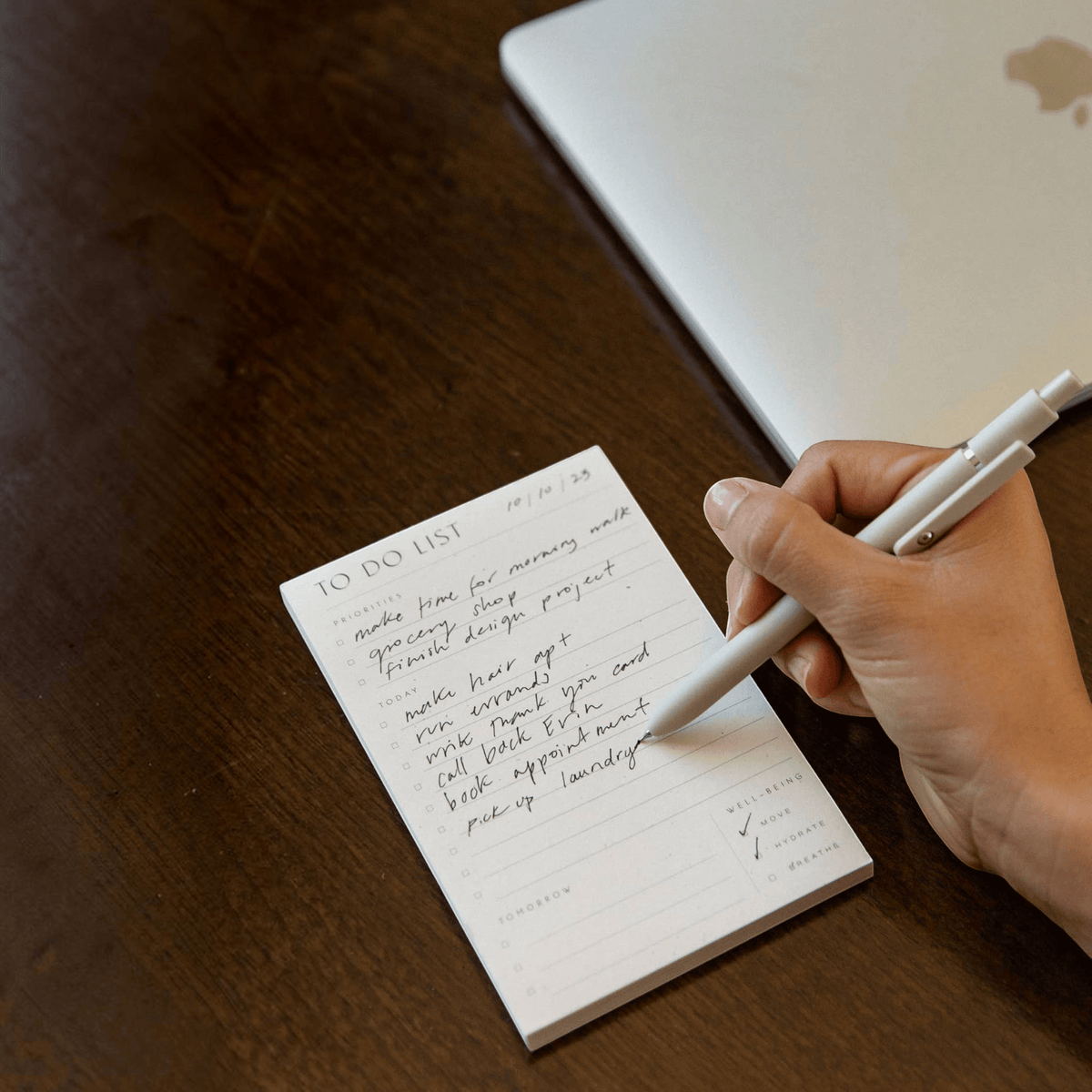 Impish Greetings Wilde House Paper to do list pad with handwritten tasks on a desk next to a laptop and pen