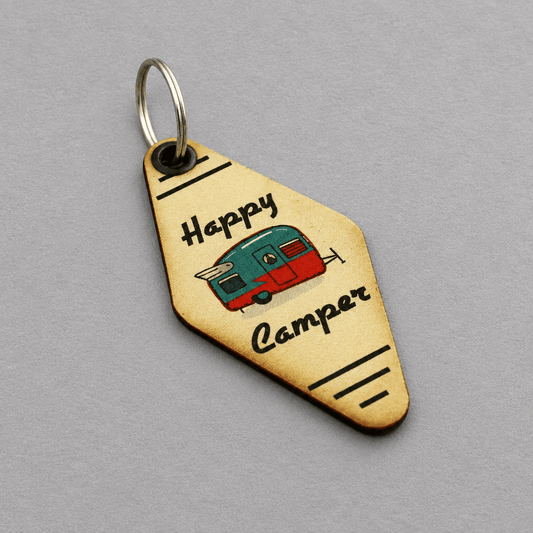 Impish Greetings wooden motel-style keychain featuring a vintage camper illustration and Happy Camper text