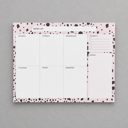 Impish Greetings weekly planner notepad with a pink and black dalmatian print border on a grey background