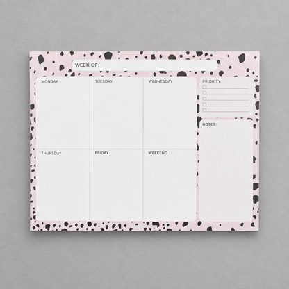 Impish Greetings Week of Productivity notepad with a pink and black dalmatian print border on a grey background.
