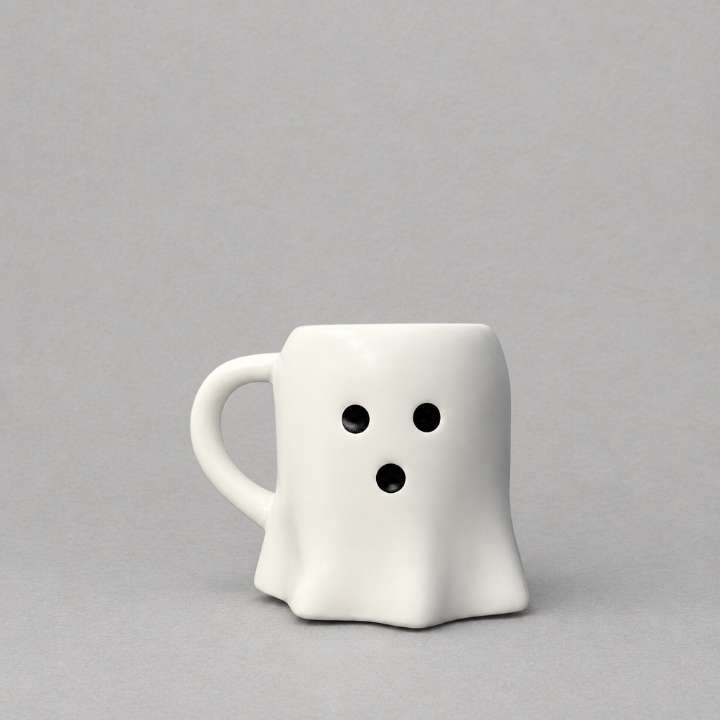 Impish Greetings white ceramic ghost-shaped coffee mug with a surprised face on a neutral grey background