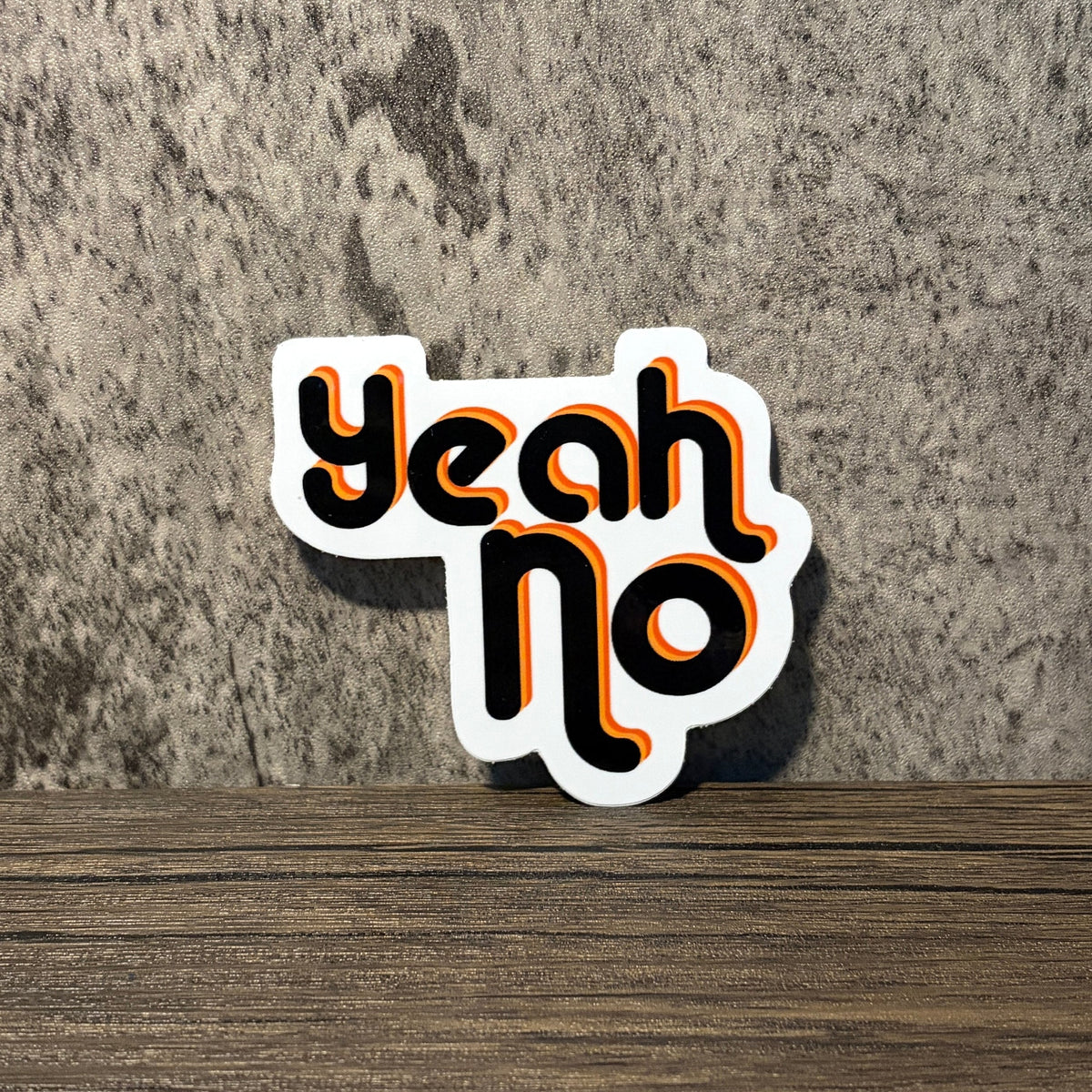 Impish Greetings Yeah No vinyl sticker with retro black and orange typography on a textured grey background.
