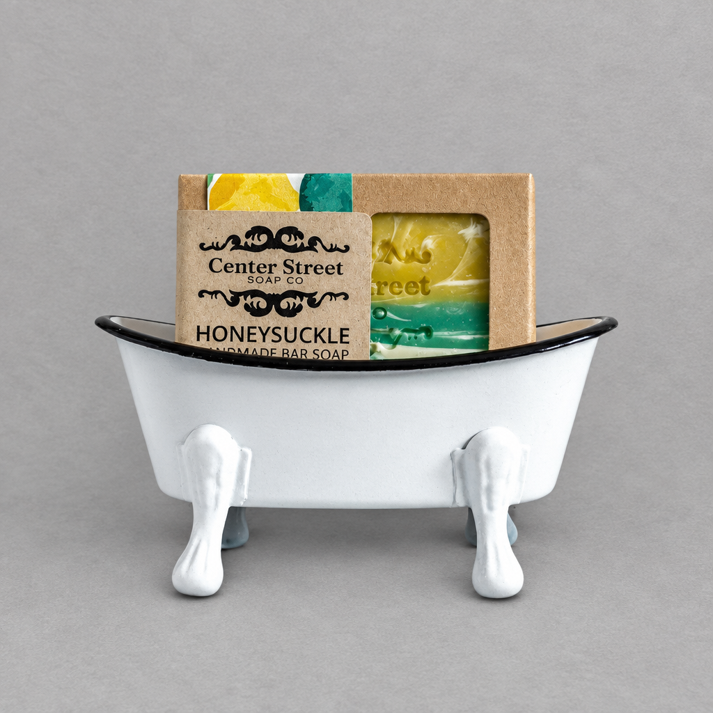 A white antique clawfoot soap holder with a white inside holding a colorful soap against a grey background