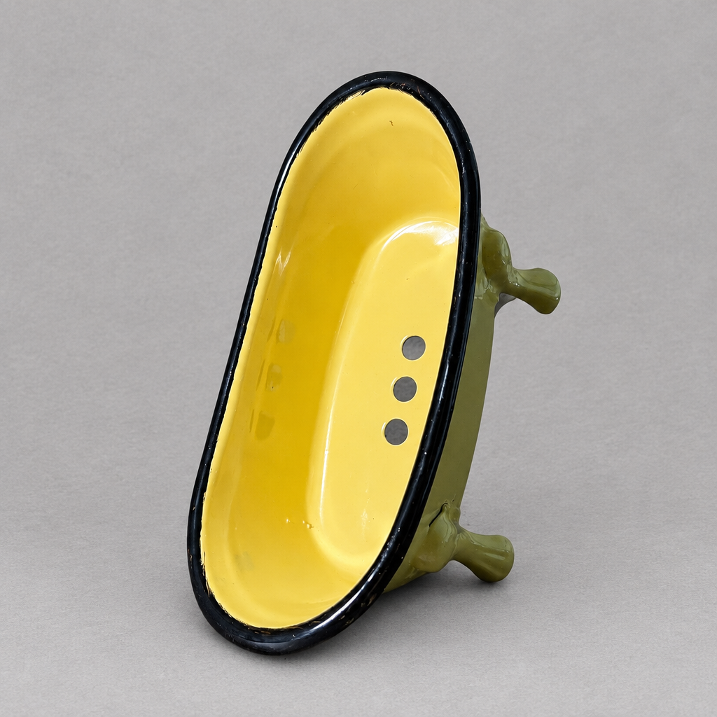 A green antique clawfoot soap holder with a yellow inside against a grey background
