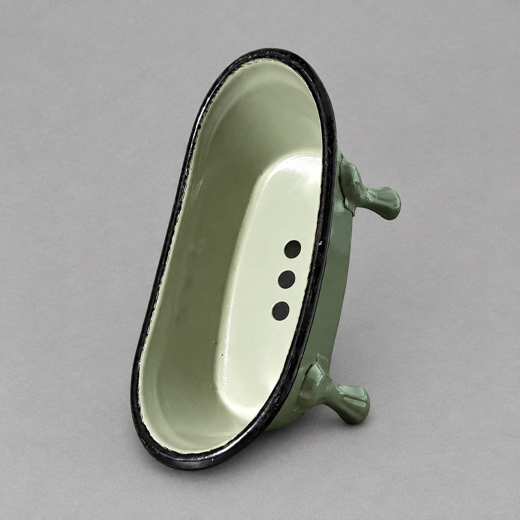 A green antique clawfoot soap holder with a green inside against a grey background