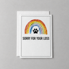 This sorry for your loss condolence card has a watercolor rainbow and paw print with the words "sorry for your loss". It is against a light grey background