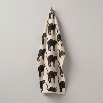 Square photo of the cat-patterned towel hanging on a hook